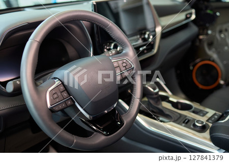 Closeup of a modern car steering wheel with control buttons for technology and convenience 127841379