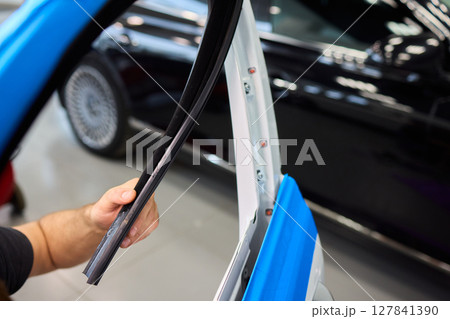 Applying spray lubricant to car door hinges helps keep them functioning smoothly Applying spray lubricant to car door hinges helps keep them functioning smoothly 127841390