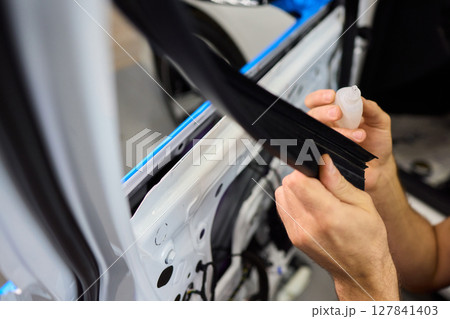 Applying spray lubricant to car door hinges helps keep them functioning smoothly Applying spray lubricant to car door hinges helps keep them functioning smoothly 127841403