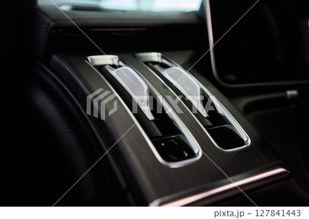 Closeup of car dashboard air vents near gear shift 127841443