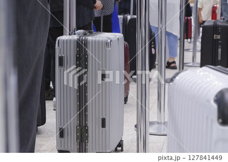 飛行機の荷物預かりに並ぶ人とスーツケース 飛行機の荷物預かりに並ぶ人とスーツケース 127841449