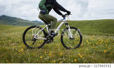 Riding mountain bike on beautiful grassland mountain top Riding mountain bike on beautiful grassland mountain top 127842531