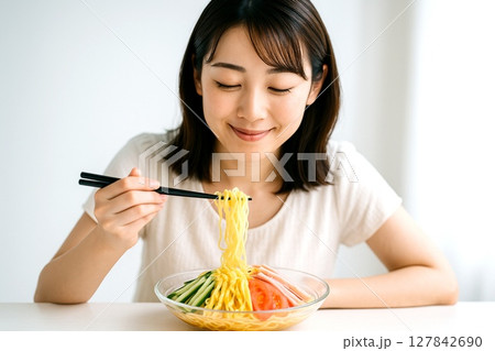 冷やし中華を食べる女性　夏の涼感と笑顔の食卓シーン 127842690