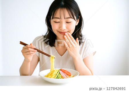 冷やし中華を食べる女性　夏の涼感と笑顔の食卓シーン 127842691