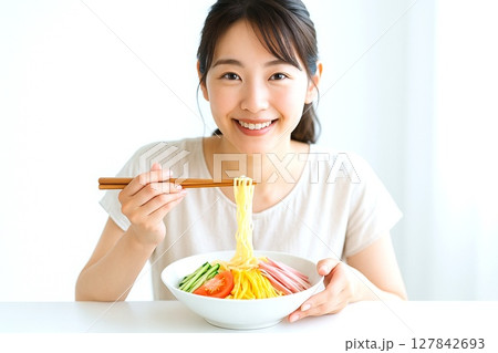 冷やし中華を食べる女性　夏の涼感と笑顔の食卓シーン 127842693