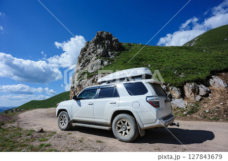 Driving off road car on high altitude mountain top 127843679