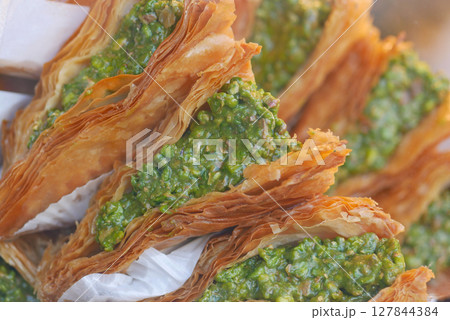 Enjoy the mouthwatering and delicious Baklava Slices that come with a delightful Pistachio Topping Enjoy the mouthwatering and delicious Baklava Slices that come with a delightful Pistachio Topping 127844384