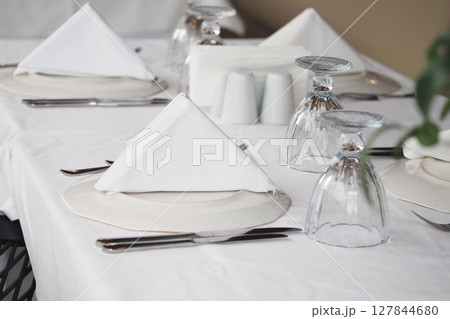 Elegant dining setup with folded napkins and glassware 127844680