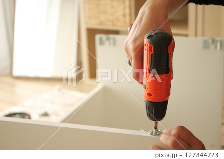 DIY furniture assembly using a cordless drill at home 127844723