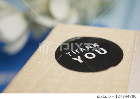 Surprise package with a thank you sticker on the lid Surprise package with a thank you sticker on the lid 127844780