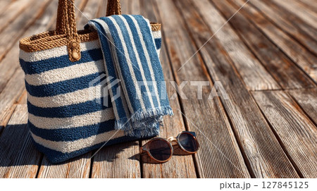 Blue Striped Beach Bag and Towel on Wooden Deck 127845125