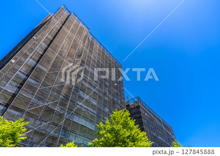 日本の横浜都市景観　マンションの補修や点検等、足場や防護ネットなど。ネットの外に衛星アンテナが… 127845888