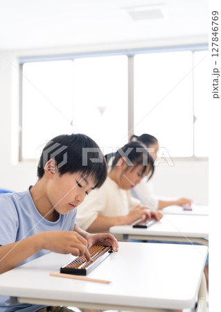 そろばん教室で学ぶ小学生 127846769