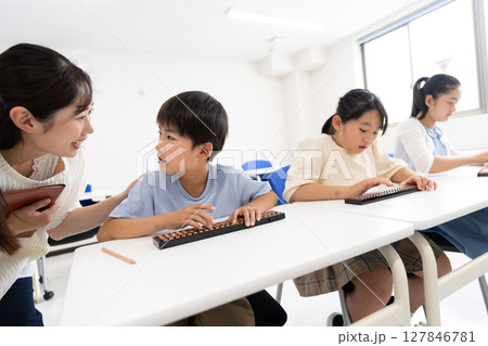 そろばん教室で学ぶ小学生 127846781