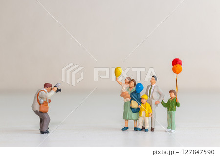 Miniature Family Posing for Photographer with Balloons 127847590