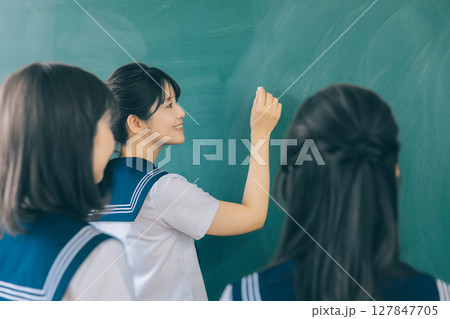 黒板に文字を書く女子高生 127847705