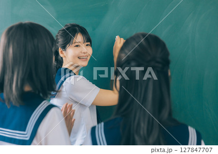 黒板に文字を書く女子高生 127847707