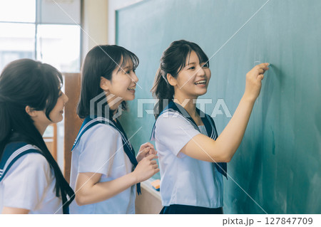 黒板に文字を書く女子高生 127847709