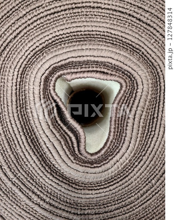 close-up view rolled fabric intricate texture and soft color tones at textile workshop. 127848314