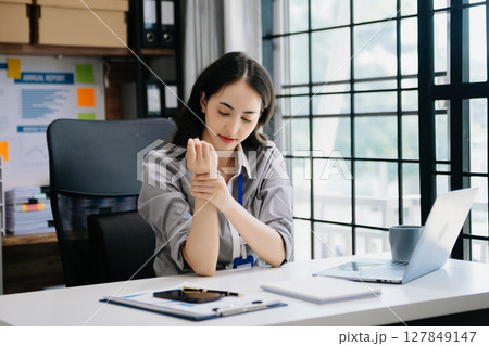 Asian woman feeling migraine head strain.Overworked businesswoman financier while working on laptop and tablet Asian woman feeling migraine head strain.Overworked businesswoman financier while working on laptop and tablet 127849147