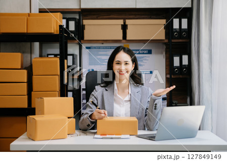 Asian woman SME working with a box the workplace. start up small business owner, small business entrepreneur SME and delivery concept. Asian woman SME working with a box the workplace. start up small business owner, small business entrepreneur SME and delivery concept. 127849149
