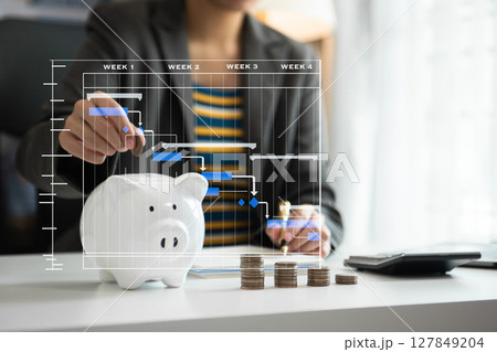 Business woman hand putting money coin into piggy bank with step of growing stack coins for saving money with virtual icon 127849204