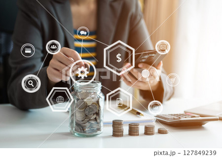 Hand putting mix coins and seed in clear bottle and business investment growth concept. at office Hand putting mix coins and seed in clear bottle and business investment growth concept. at office 127849239