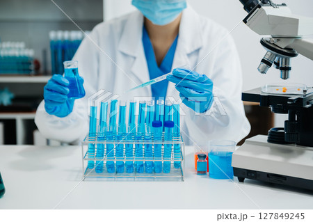 Modern medical research laboratory. female scientist working with micro pipettes analyzing biochemical samples, advanced science chemical laboratory 127849245