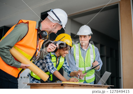 Architect caucasian man working with colleagues mixed race in the construction site. Architecture engineering on big project. Building in construction interior. 127849415