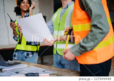 Engineer Teamwork Meeting, Drawing working on blueprint meeting for project working with partner on model building at company office. 127849499