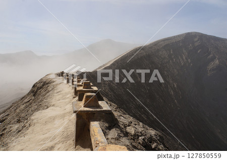 View from crater rim seats and safety barriers for sightseeing tourists, Bromo Mountain, Indonesia 127850559
