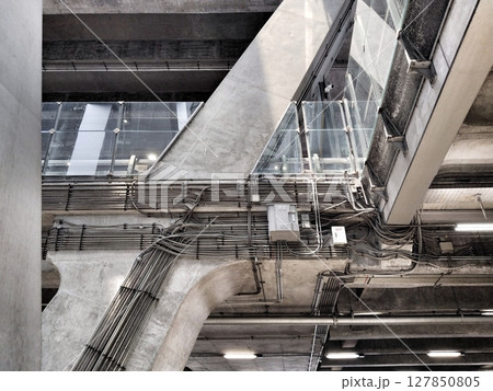 Showcasing a multi-layered urban building scene focusing on the intricate networks of exposed utility pipes, cables, and architectural details 127850805