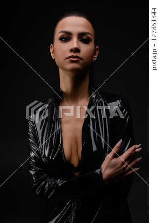 Striking portrait of a confident woman with elegant beauty in a dark setting Striking portrait of a confident woman with elegant beauty in a dark setting 127851344