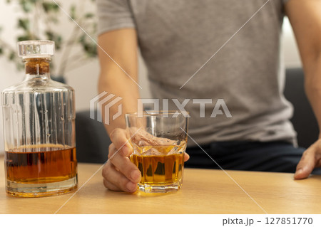 Alcohol addicted man sleeping at the table. Sad depressed male adult having troubles with alcohol. 127851770