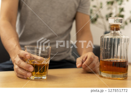 Alcohol addicted man sleeping at the table. Sad depressed male adult having troubles with alcohol. 127851772