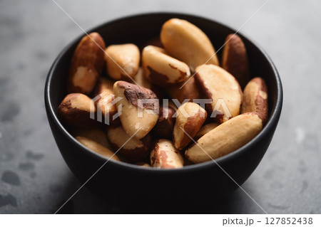 brazil nuts in black bowl on terrazzo countertop 127852438