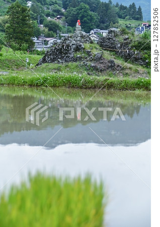 水田に映り込む銘石と地蔵尊 127852506