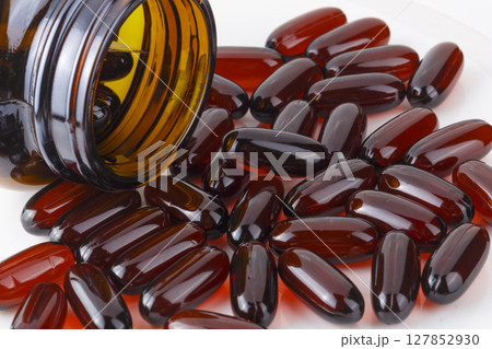 Soft gel capsules filled with essential vitamins, offering easy-to-swallow daily supplements for improved health and nutrient absorption, isolated on a white background Soft gel capsules filled with essential vitamins, offering easy-to-swallow daily supplements for improved health and nutrient absorption, isolated on a white background 127852930