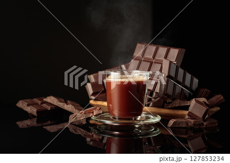 Mug of hot chocolate against broken bitter chocolate bars. 127853234