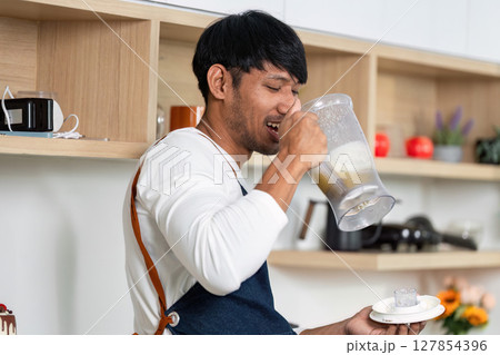 LGBT Couple Enjoying Healthy Drink in Modern Kitchen LGBT Couple Enjoying Healthy Drink in Modern Kitchen 127854396