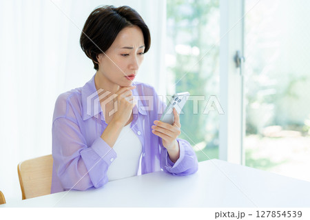 スマホを持って考える女性 127854539