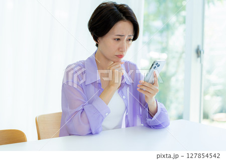 スマホを持って考える女性 127854542