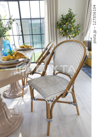 Stylish interior of dining room at cozy home , decoration and elegant personal accessories in modern home decor.  127856104