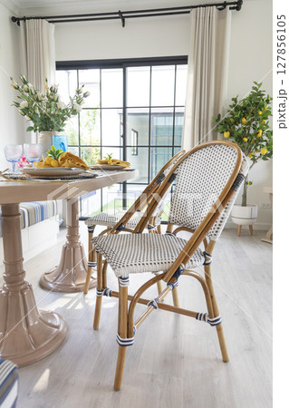 Stylish interior of dining room at cozy home , decoration and elegant personal accessories in modern home decor.  127856105