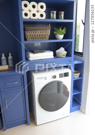 Modern washing machine and shelving unit in laundry room interior Modern washing machine and shelving unit in laundry room interior 127856235
