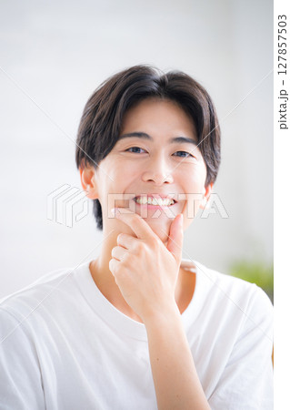 若いハンサムな男性の美容やビューティーの透明感、爽やかスキンケアイメージ 顎に手を当てて考える 若いハンサムな男性の美容やビューティーの透明感、爽やかスキンケアイメージ 顎に手を当てて考える 127857503