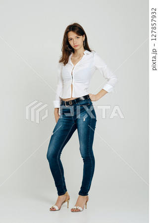 Teenager posing confidently in stylish outfit against plain background indoors Teenager posing confidently in stylish outfit against plain background indoors 127857932