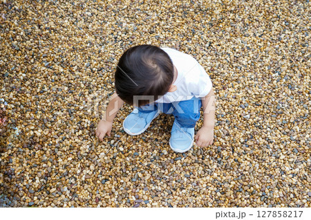 Toddler Playing with Pebbles 127858217