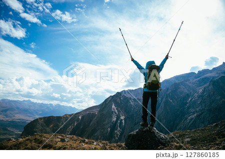 Backpacking woman hiking on high altitude mountain top 127860185