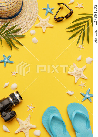 Summer accessories framing vibrant yellow background for travel planning Summer accessories framing vibrant yellow background for travel planning 127861202